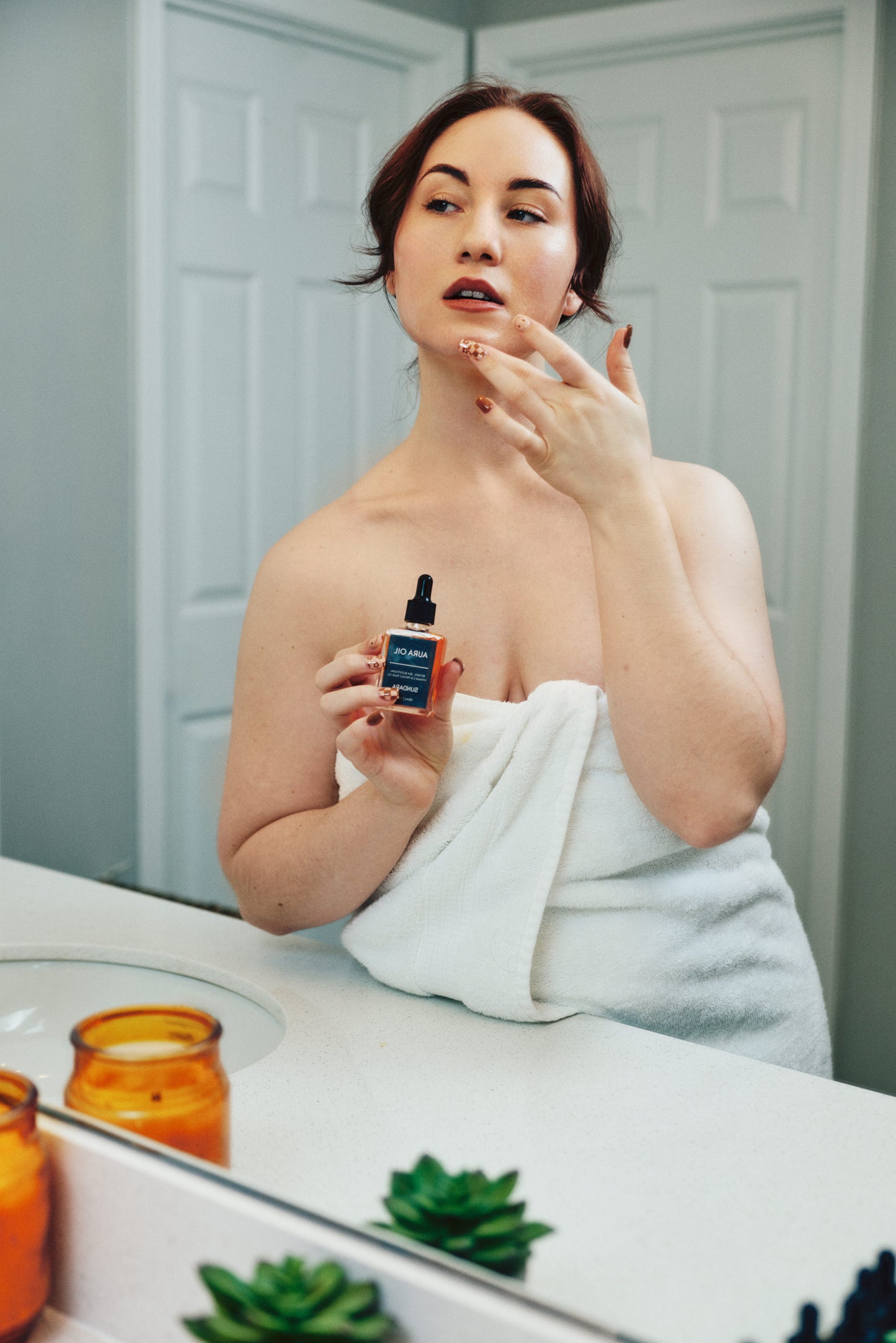 Woman applying skincare product in front of a mirror