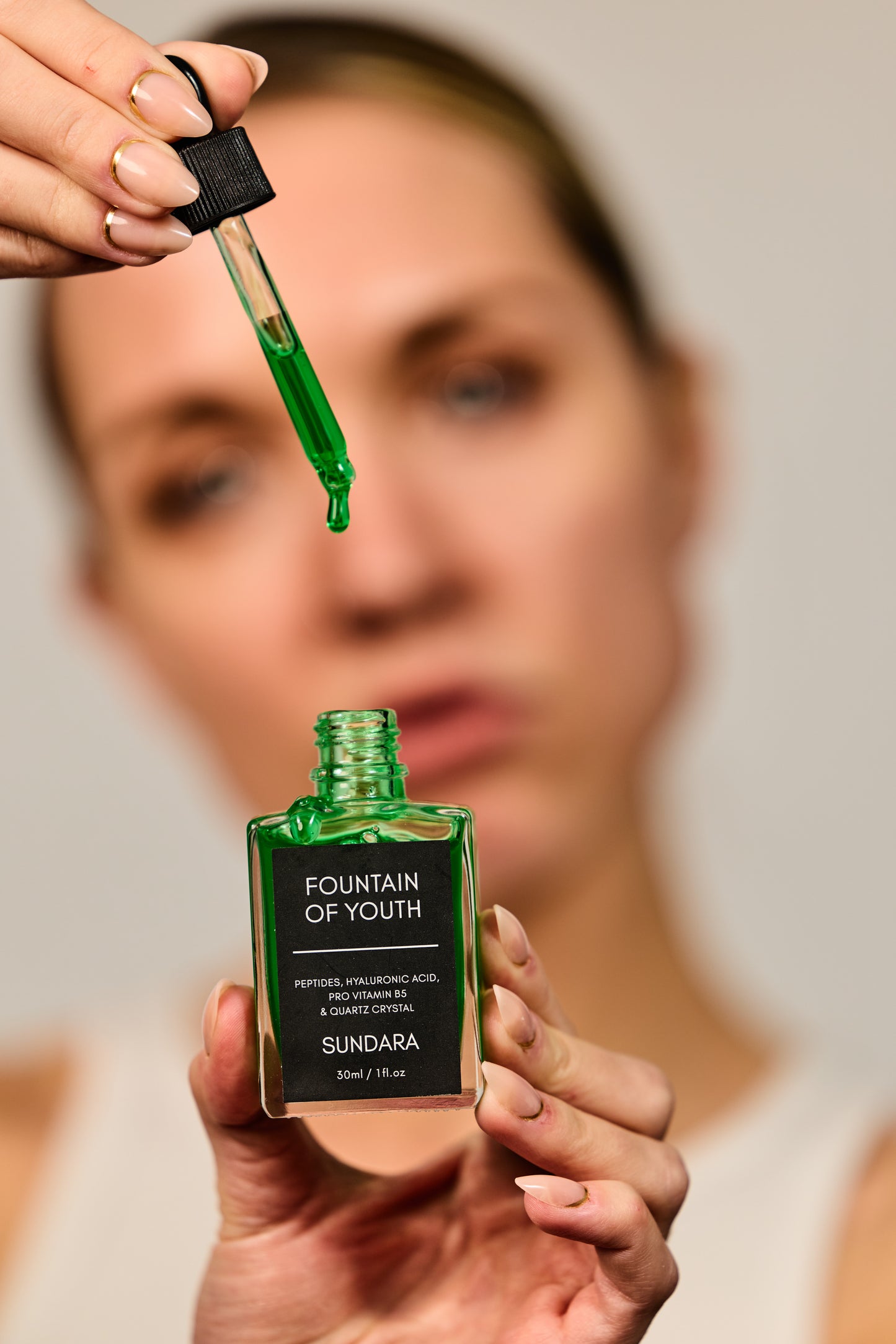 Sundara Fountain of Youth skincare product with a dropper held by a person against a blurred background