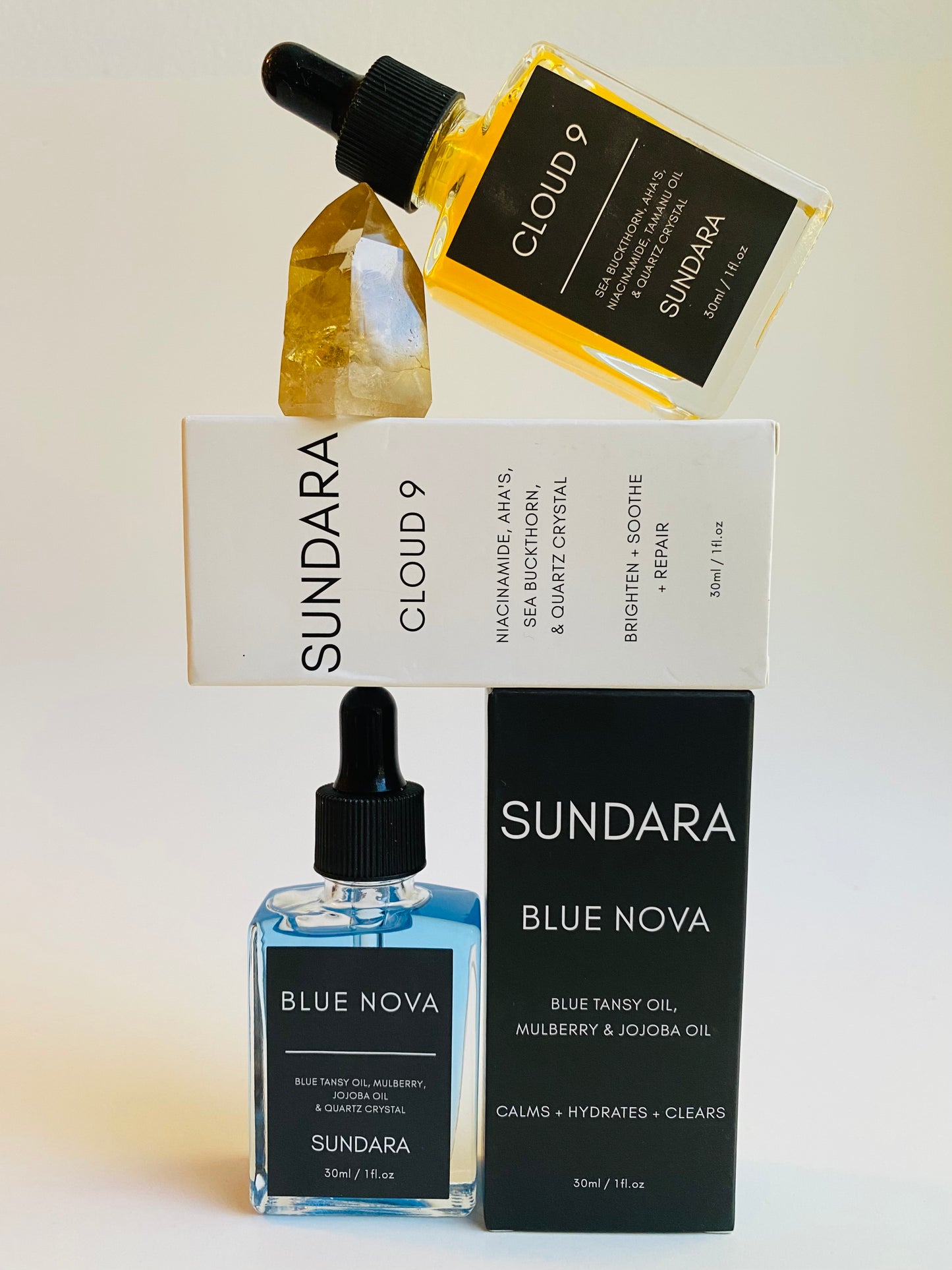 Soul of Sundara Blue Nova and Cloud 9 quartz crystal skincare serum combo pack  balancing on a quartz crystal