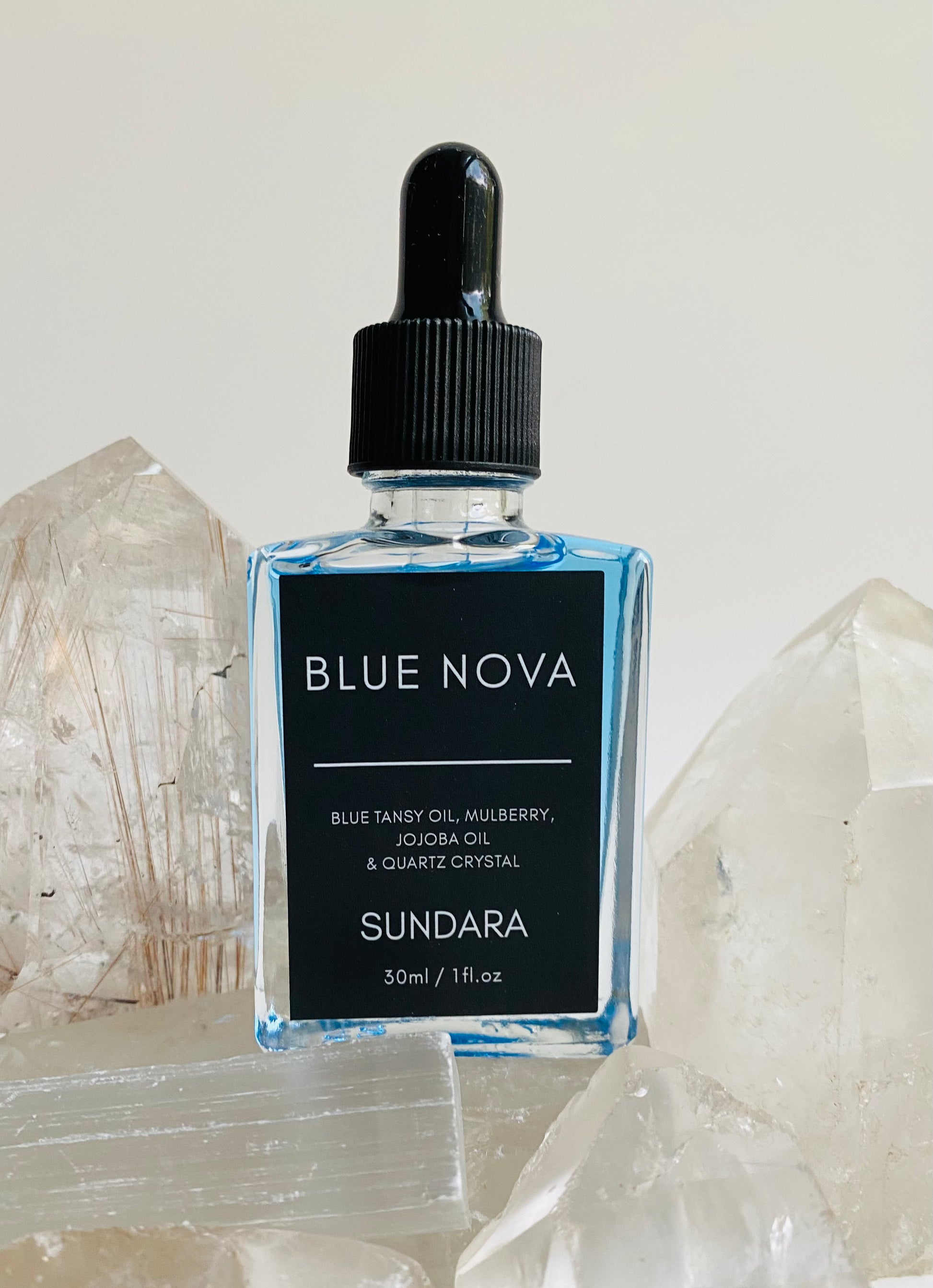Soul of Sundara Blue Nova oil balancing on quartz crystal. Blue tansy oil, mulberry, jojoba oil, and quartz crystal soothing skincare