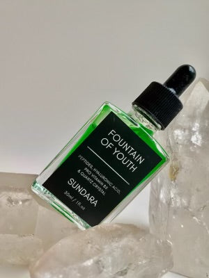 Soul of Sundara Fountain of Youth Serum propped on quartz crystal. Peptides, hyaluronic acid, quartz crystal for aging skin