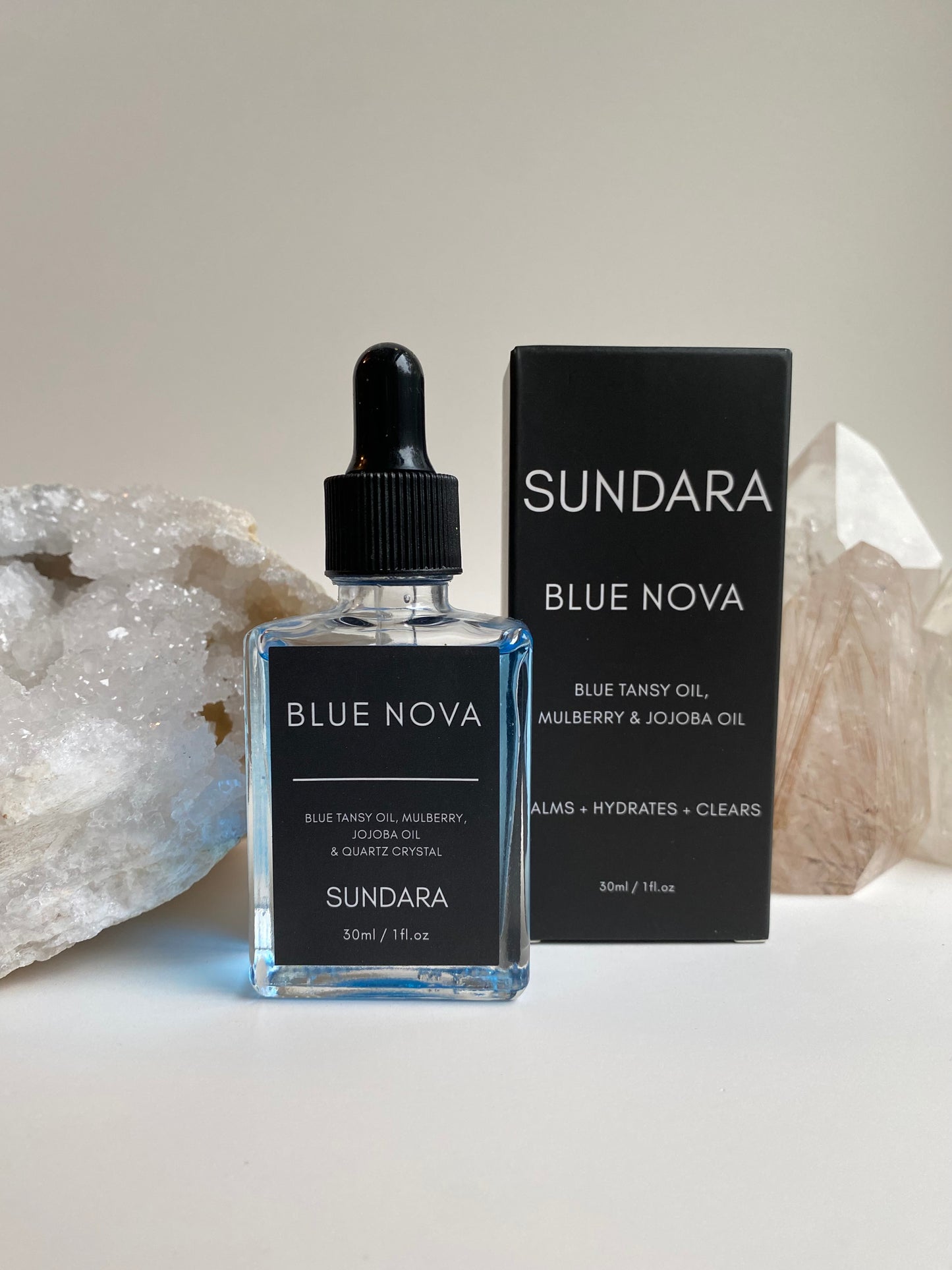 Soul of Sundara Blue Nova oil balancing on quartz crystal. Blue tansy oil, mulberry, jojoba oil, and quartz crystal soothing skincare