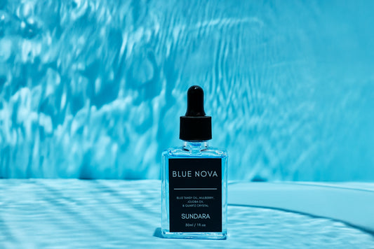 Blue Nova skincare bottle with dropper on a blue background